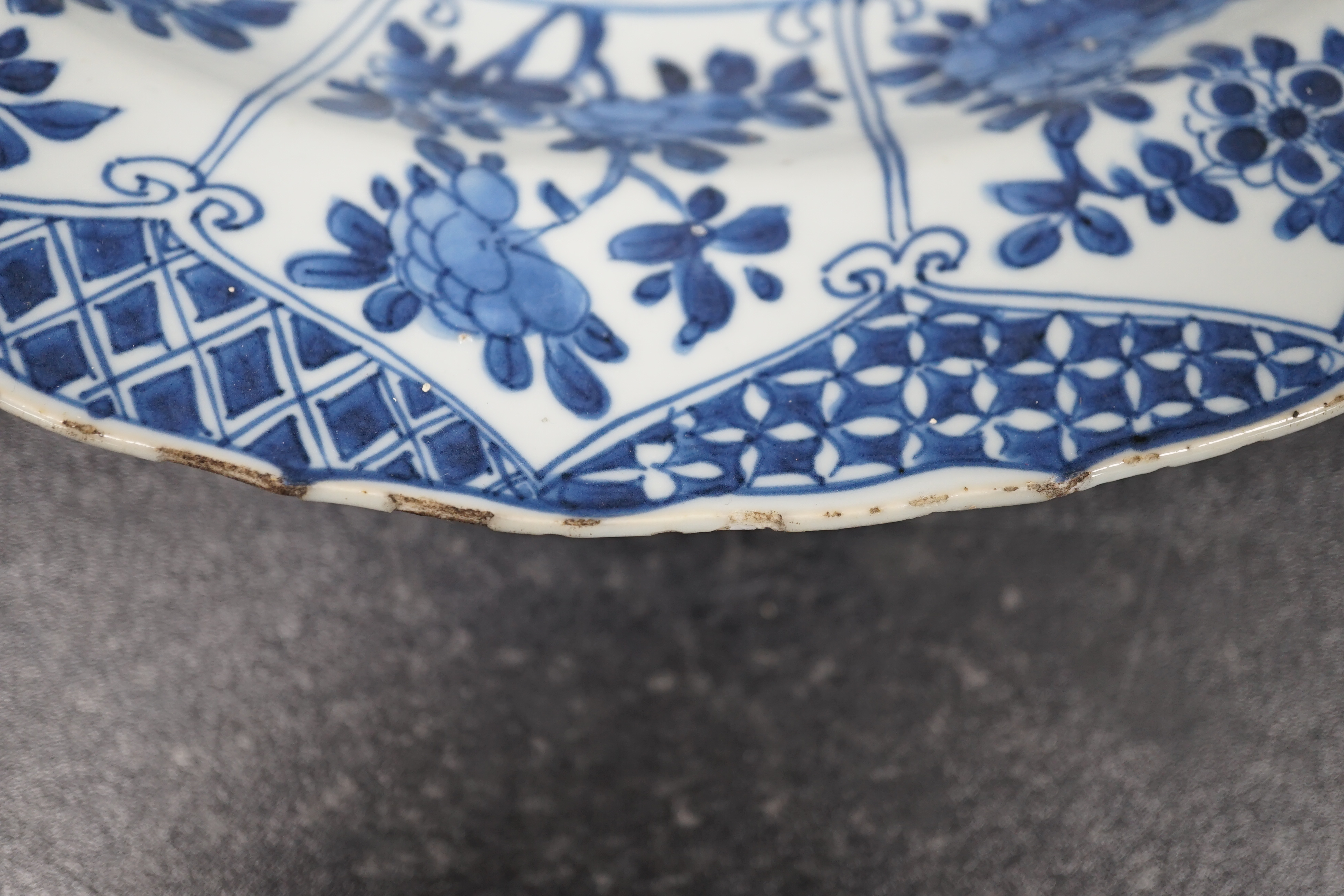 A pair of Chinese blue and white ‘garden’ dishes, Kangxi period, fritting and glaze chips